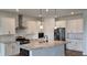 A modern kitchen with stainless steel appliances, white cabinets, granite countertops, and pendant lighting at 19492 Fort King Run, Brooksville, FL 34601