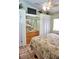 Bedroom showcases a ceiling fan, TV, closet, large window, and mirrored wall accents at 20861 Haulover Cv # C4, Lutz, FL 33558