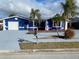 Blue house with white trim, attached garage, and palm trees at 7446 Donegal St, New Port Richey, FL 34653