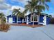 Blue house with white trim, attached garage, and palm trees at 7446 Donegal St, New Port Richey, FL 34653