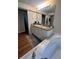 Bathroom featuring a double vanity with granite countertops, a soaking tub, and a large mirror at 800 61St N St, St Petersburg, FL 33710