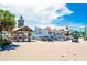 John's Pass Boardwalk features various shops and restaurants under a partly cloudy blue sky at 800 61St N St, St Petersburg, FL 33710