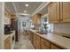 Galley-style kitchen boasting light wood cabinets and stainless steel appliances at 3960 Lema Dr, Spring Hill, FL 34609