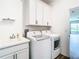 Laundry room with white cabinets, LG washer and dryer, and sink at 19492 Fort King Run, Brooksville, FL 34601
