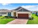 Single-story house with a brick driveway and well-manicured lawn at 19492 Fort King Run, Brooksville, FL 34601