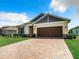 House exterior with a brown garage door and blue shutters at 19492 Fort King Run, Brooksville, FL 34601