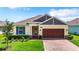 House exterior with a brown garage door and blue shutters at 19492 Fort King Run, Brooksville, FL 34601