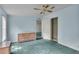 Bedroom with teal carpet, dresser, ceiling fan, and closet at 9520 Merton St, New Port Richey, FL 34654