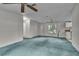 Spacious living room with teal carpet and access to kitchen at 9520 Merton St, New Port Richey, FL 34654