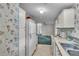 Kitchen with white cabinets and floral wallpaper at 9520 Merton St, New Port Richey, FL 34654