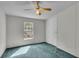Bright bedroom featuring carpet, ceiling fan, and a window at 9520 Merton St, New Port Richey, FL 34654