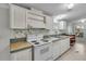 White kitchen with stove, cabinets, and floral wallpaper at 9520 Merton St, New Port Richey, FL 34654