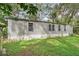 Mobile home exterior with multiple windows and overgrown yard at 9520 Merton St, New Port Richey, FL 34654