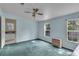 Light blue bedroom with teal carpet, ceiling fan, and window at 9520 Merton St, New Port Richey, FL 34654