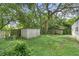 Large backyard with mature trees and storage sheds at 9520 Merton St, New Port Richey, FL 34654