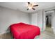 Bright bedroom with red bedding and ceiling fan at 7446 Donegal St, New Port Richey, FL 34653