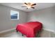 Bedroom with red bedding, ceiling fan, and window at 7446 Donegal St, New Port Richey, FL 34653