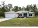 Newly built home with a two-car garage and manicured lawn at 15492 Pomp Pkwy, Weeki Wachee, FL 34614