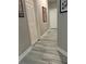 Long hallway with light grey wood-look tile flooring at 20521 Homossasa Ct, Land O Lakes, FL 34637