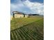 Large backyard with a grassy lawn and a home with solar panels at 15434 Miller Creek Dr, Sun City Center, FL 33573