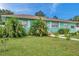 Light teal home with a well-manicured lawn and tropical landscaping at 800 61St N St, St Petersburg, FL 33710