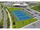 Scenic aerial view of tennis courts, lush landscaping, and surrounding parking and school at 3893 Burdick Loop, Odessa, FL 33556