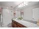 Bright bathroom features a granite countertop vanity, a tub with shower, and modern fixtures at 3893 Burdick Loop, Odessa, FL 33556