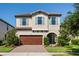 Charming two-story home features a well-manicured lawn, tile roof, blue shutters, and a two car garage at 3893 Burdick Loop, Odessa, FL 33556