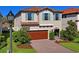 Charming two-story home with a red tile roof, turquoise shutters, and brick driveway at 3893 Burdick Loop, Odessa, FL 33556