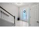 Welcoming foyer boasts a decorative door, staircase with wood banister, and neutral tile flooring at 3893 Burdick Loop, Odessa, FL 33556