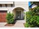 Inviting front entrance with beautiful landscaping, brick walkway, and arched entryway at 3893 Burdick Loop, Odessa, FL 33556