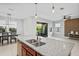 Open-concept kitchen featuring an island sink with granite countertops, dark wood cabinetry, and a dining area at 3893 Burdick Loop, Odessa, FL 33556