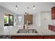 Kitchen island with granite countertop, stainless sink and view of the living room with accent wall at 3893 Burdick Loop, Odessa, FL 33556