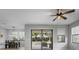 Bright, open living room with patio access, a ceiling fan, views to the backyard, and a dining area at 3893 Burdick Loop, Odessa, FL 33556