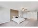 Large main bedroom with neutral carpet, a ceiling fan, a panel feature wall behind the bed, and en suite at 3893 Burdick Loop, Odessa, FL 33556