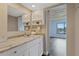 Updated bathroom featuring a large mirror, white vanity with decorative hardware, and views to the main bedroom at 8210 Aquila St # 227, Port Richey, FL 34668