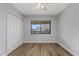 Bright bedroom featuring wood-look floors, a window with community views, and a double-door closet at 8210 Aquila St # 227, Port Richey, FL 34668