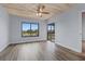 Well-lit bedroom featuring a wood plank ceiling, wood-look floors, a sliding door to the screened patio, and a large window at 8210 Aquila St # 227, Port Richey, FL 34668