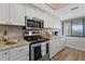 Well-lit kitchen showcasing stainless steel appliances, granite countertops, tiled backsplash, and ample white cabinetry at 8210 Aquila St # 227, Port Richey, FL 34668