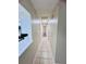 Long hallway with light neutral walls and tile flooring at 8141 Bugle Ct # 1, Port Richey, FL 34668