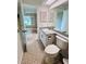 Bathroom with gray vanity, tiled floor, and a toilet at 8141 Bugle Ct # 1, Port Richey, FL 34668