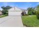 Single-story house with two-car garage, American flag, and well-manicured lawn at 2952 Wood Pointe Dr, Holiday, FL 34691