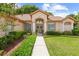 Inviting front entrance with a walkway and manicured landscaping at 4309 Hunters Pass, Spring Hill, FL 34609