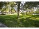 Lush community park with green grass, shady trees, a picnic pavilion and a tranquil lake in the background at 6635 Stewart N Ave, St Petersburg, FL 33702