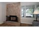 The living room includes a unique stone fireplace and large window providing ample natural light at 6635 Stewart N Ave, St Petersburg, FL 33702