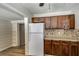 The kitchen features dark wood cabinets, a refrigerator, and modern countertops for meal preparation at 6635 Stewart N Ave, St Petersburg, FL 33702