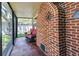 Enclosed patio features a red brick wall and a comfortable wicker seating area with a decorative 'stay awhile' pillow at 6635 Stewart N Ave, St Petersburg, FL 33702