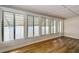 Sunny sunroom showcasing wood-look floors and bright natural light from the multiple large windows at 6635 Stewart N Ave, St Petersburg, FL 33702