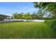 Large backyard with lush grass and a large tree at 7504 Cypress Knee Dr, Hudson, FL 34667
