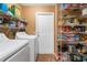 Laundry room with washer, dryer, and ample storage shelving at 7504 Cypress Knee Dr, Hudson, FL 34667